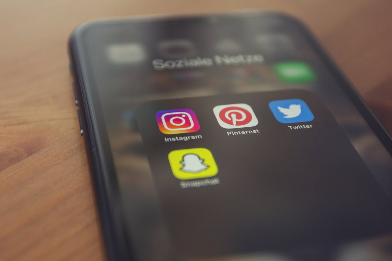 creative-02 Smartphone displaying popular social media apps like Instagram, Pinterest, Twitter, and Snapchat.
